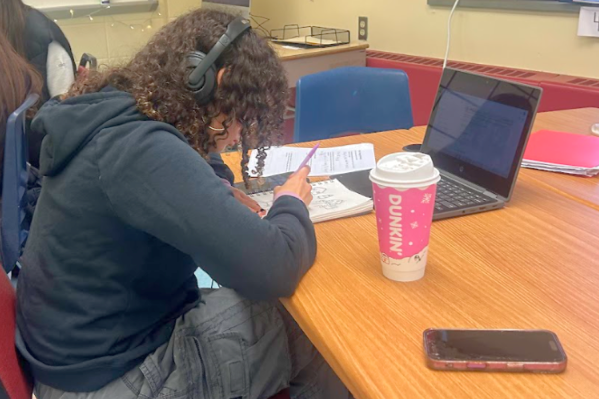 Student intensively working on an assignment while having their favorite winter drink nearby.
