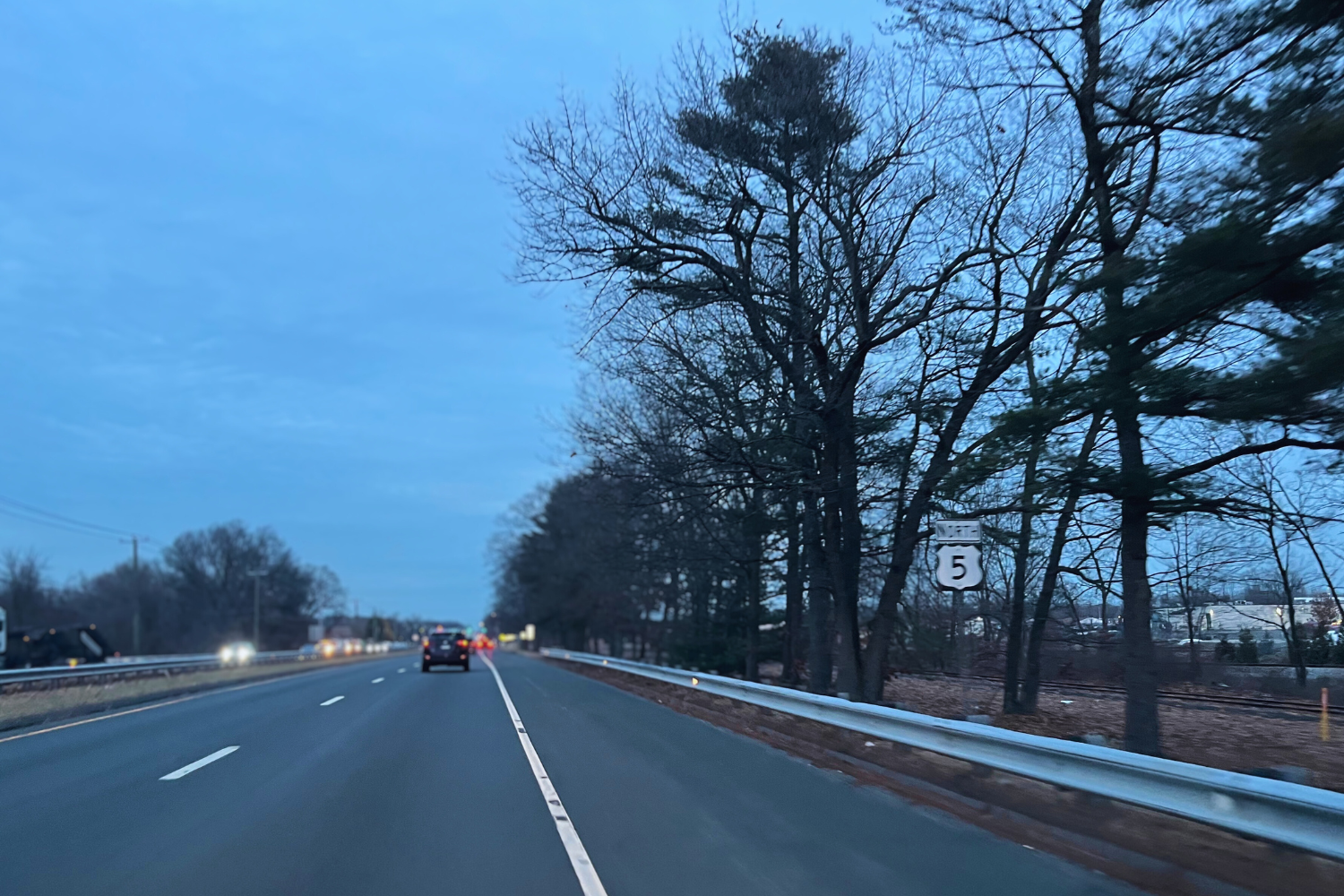 Several cars driving down South Windsor's Route 5 in the late afternoon. 