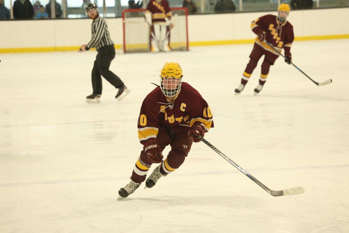 Senior captain Junior Heredia skates up the ice during the Bobcats win over Woodstock Academy.