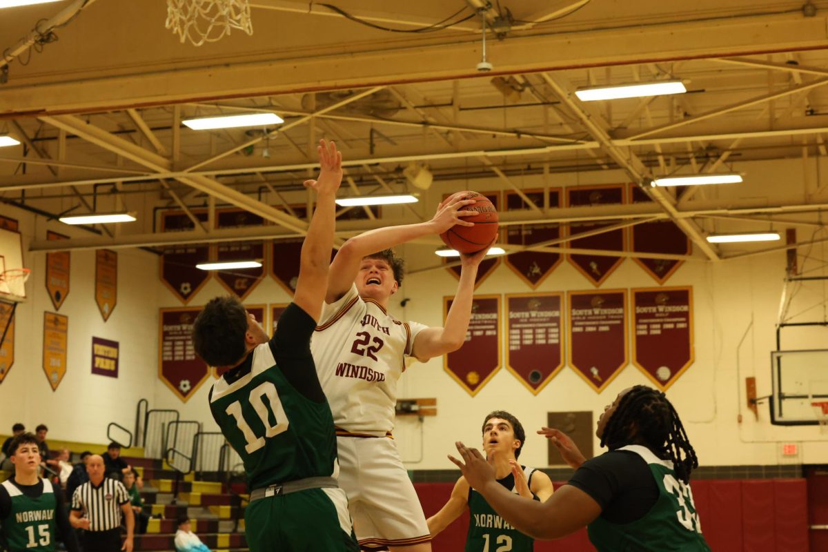 Ryder Haynes drives into the lane and shoots the ball over a Norwalk defender.