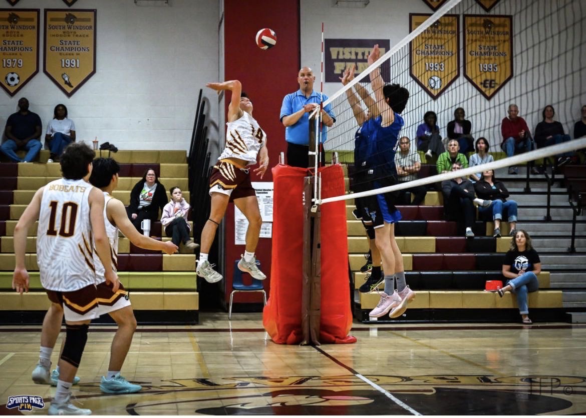 Owen Jerr spikes the ball through the opposition blockers in a home game against Hall High School. (Photo courtesy of Timothy Fetzko)