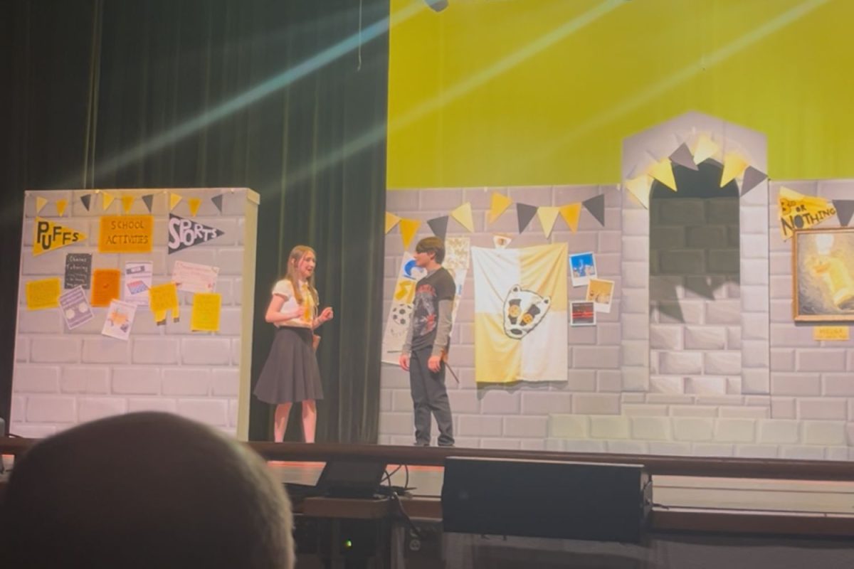 Two characters Wayne and Sally Perks share a romantic moment on the stage during Puffs.